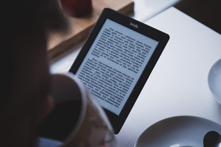 E-Readers and Digital Publishing: A New Chapter for Books A reader holding an e-reader while reading an e-book